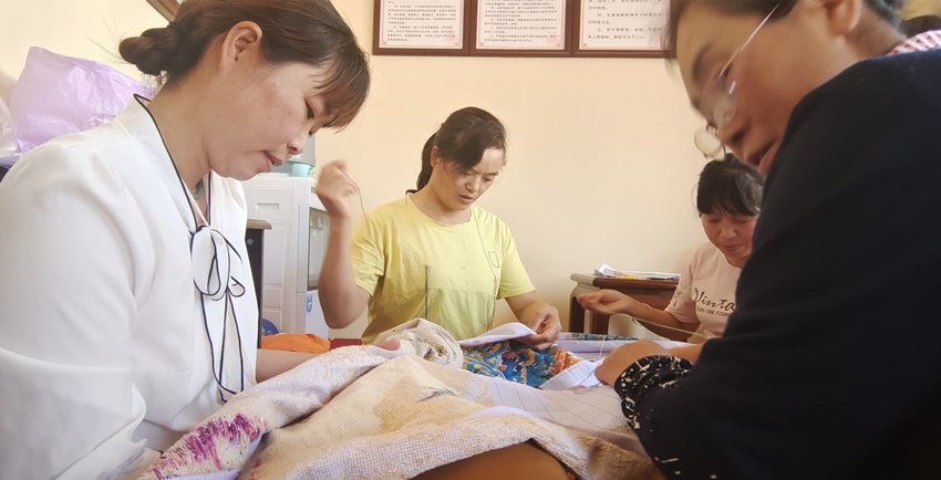 張菊花與繡女們正在趕制“百鳥朝鳳”繡圖。楊奇國供圖