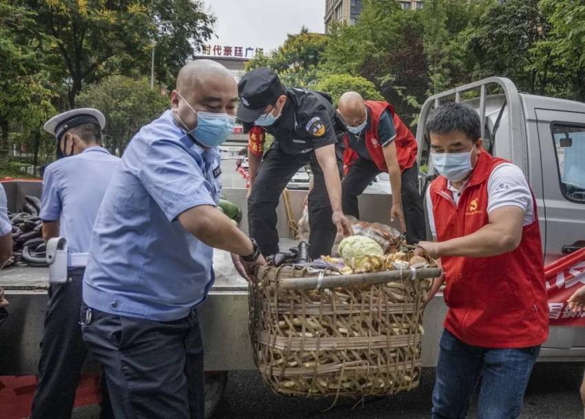 協助志愿者搬運物資。成都市公安局郫都區分局供圖