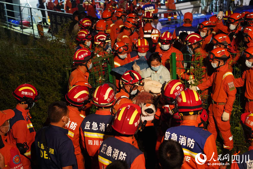 9月5日晚，雅安消防支隊在新民鄉碼頭，消防救援人員與多方救援力量一起運送傷員。鄭竺青攝