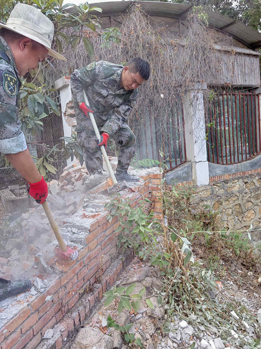 楊?lèi)?ài)理（右一）在拆除危墻。陸軍第77集團(tuán)軍某旅供圖