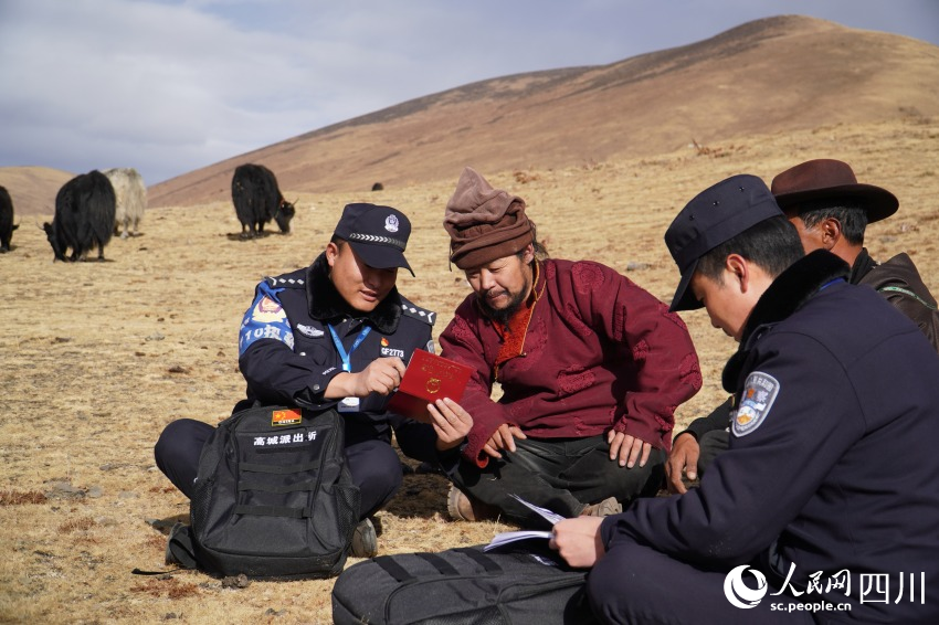 民警為牧民洛絨扎西送來補辦好的戶口本。人民網 趙祖樂攝