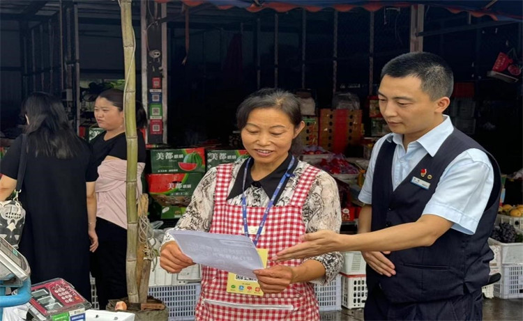 雙流航空港支行人員在成都農產品批發市場為商戶介紹聚合支付服務。建行四川省分行供圖