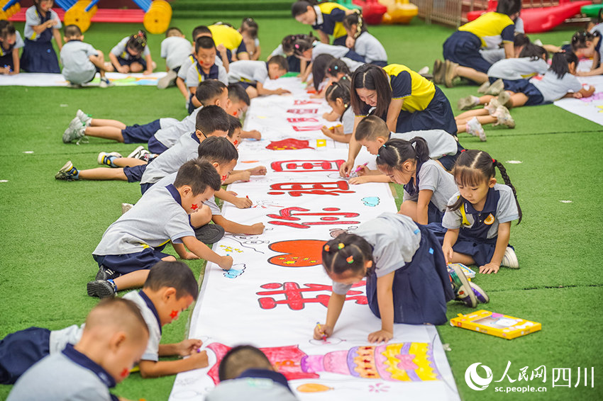 9月29日，眉山市彭山區(qū)幼兒園師生們?cè)谛@內(nèi)繪畫(huà)祝福祖國(guó)。翁光建攝