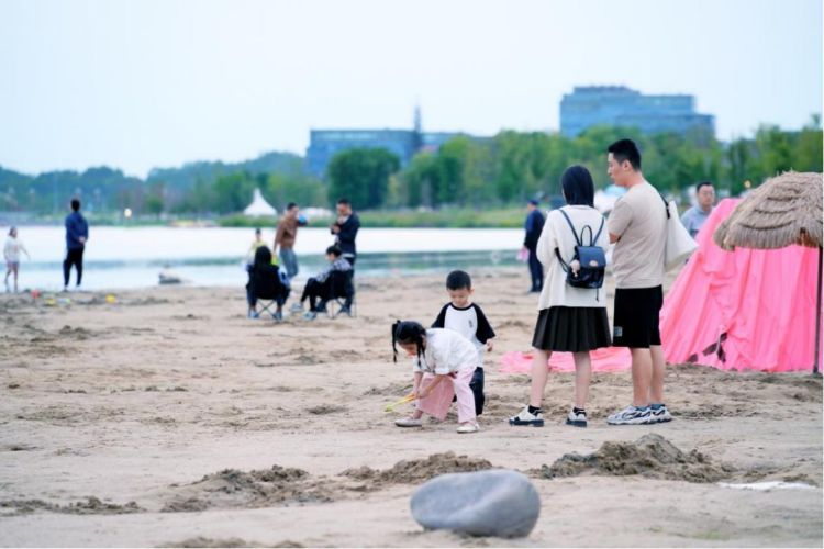 小朋友在興隆湖畔玩海沙。天府新區(qū)融媒體中心供圖